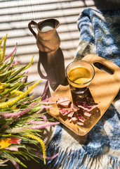 in bed, black coffee in a glass cup, a milk jug, crushed pink chocolate on a blackboard and a bouquet of wildflowers, low light, vertical frame
