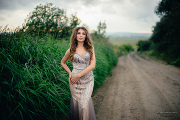 Obraz premium beautiful young girl in a summer dress in a field on a background of green grass