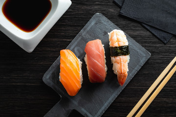 Elegant sushi on wood table. Some Nigiri, with soy sauce and chopstick