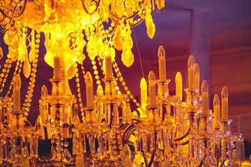 large yellow chandelier with candles on a ceiling in theater