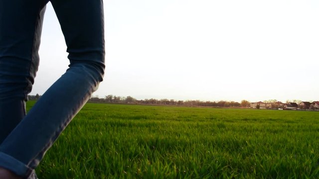 Boy walking on grass during spring, golden hour.