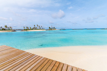 Fototapeta na wymiar Amazing island in the Maldives ,wooden bridge and beautiful turquoise waters with blue sky background for holiday vacation .