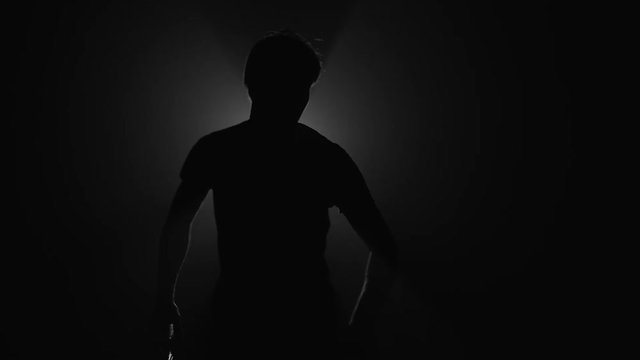 Silhouette of man playing squash