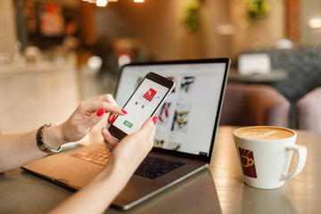 Women hands using smartphone and laptop computer for online shopping. Payment Detail page display.