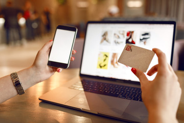 Women hands using smartphone and laptop computer for online shopping. Payment Detail page display.