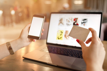 Women hands using smartphone and laptop computer for online shopping. Payment Detail page display.