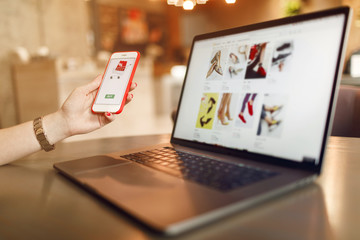 Women hands using smartphone and laptop computer for online shopping. Payment Detail page display.