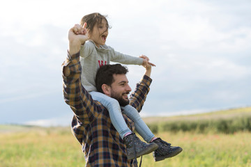 Father with little girl on his shoulder in outdoors spring image