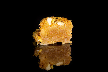 One half of sweet lebanese baklava piece bird nest variety isolated on black glass