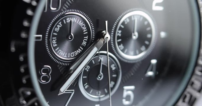Macro, closeup of a men's silver watch with the time at 7:35.