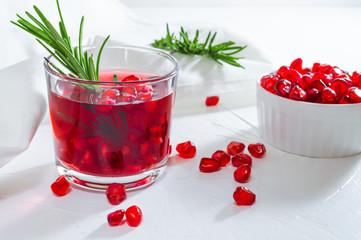 Summer drink with pomegranate and rosemary. White background.