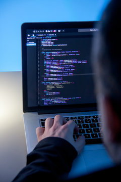 Programmer working on laptop computer in office