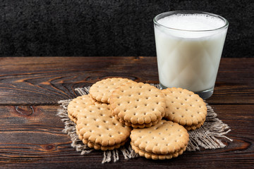 Cookies with milk filling on dark wooden background