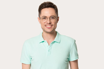 Smiling Caucasian man in polo and glasses posing in studio