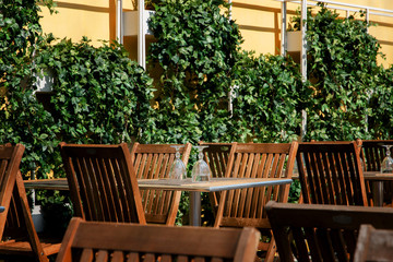 clean inverted glasses on the wooden tables in the summer cafe