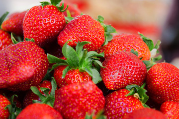 red ripe juicy strawberries on the market showcase fresh crop, selective focus