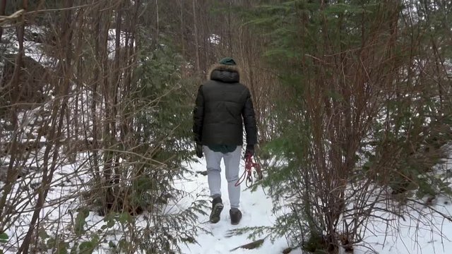 man young hiking through bush and snow in Canada, 120 fps super slow motion