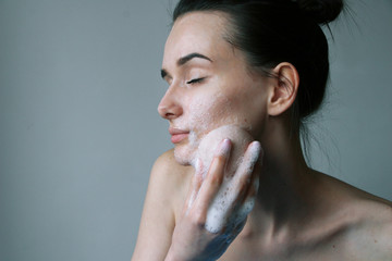 girl washes her face with sponge