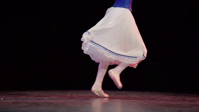 A ballerina dances en pointe on stage during a performance.