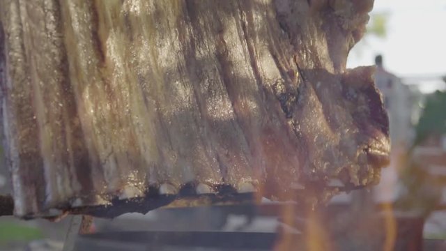 Close Up of Argentinian Asado, Grilled Meat, Skewered In A Spit For Roasting