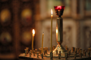 Orthodox Church. Wax candles burn against the background of old icons. Dark interior. Religious plot