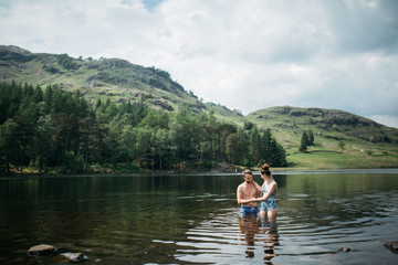 Man helping woman from a lake