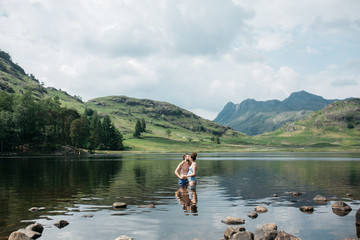 Couple kissing while swimming on a dramatic landscape