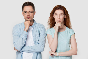 Pensive couple touch chin with finger thinking of something