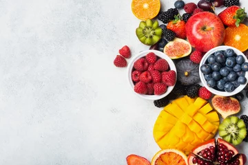 Fototapeten Healthy raw rainbow fruits, mango papaya strawberries oranges passion fruits berries on oval serving plate on light kitchen top, top view, copy space, selective focus © Liliya Trott