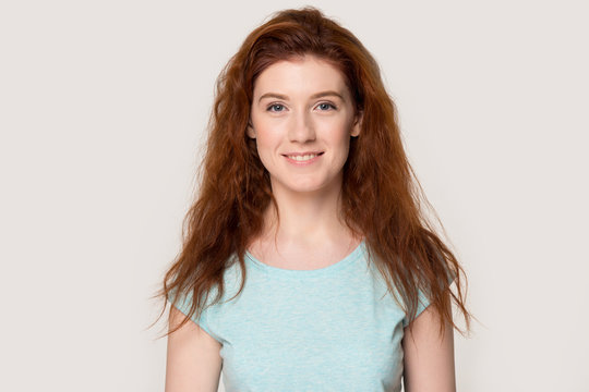 Portrait of smiling redhead female posing in studio