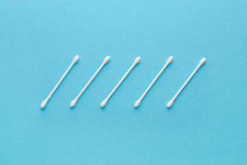 white cotton swabs on blue background, flatlay
