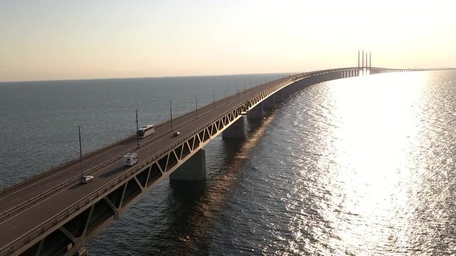 4K inspire 2 drone footage of the Öresundsbridge in Southern Sweden close up with cars driving onto the bridge during sunset.
