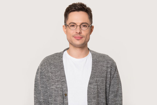 Portrait of millennial man in glasses isolated on grey background