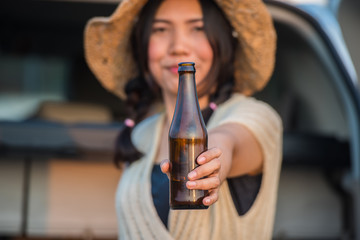 Beautiful woman with a drink bottle on the car