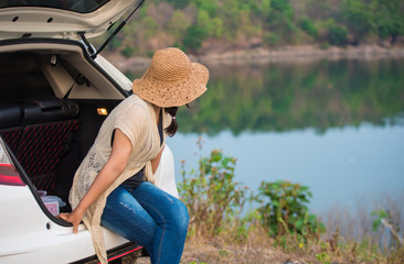 Fototapeta premium Beautiful woman sitting behind the car
