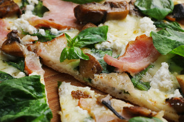 pizza with bacon mushrooms and basil close up one piece cut off