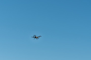 Drone flying in the air against the blue sky.technology and radio-controlled machines