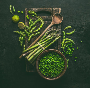 Green Cooking Ingredients. Green Asparagus With Edamame Soybeans, Lime And Green Peas On Dark Rustic Kitchen Table Background, Top View.  Healthy Vegetarian Food