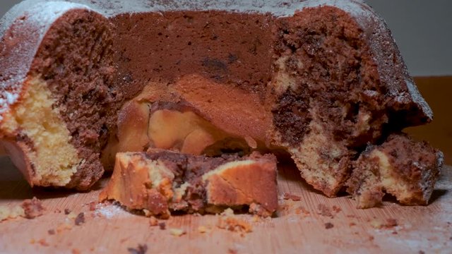 Traditional marble cake on wooden plate, wonam slicing up a cake, cutting cake with knife