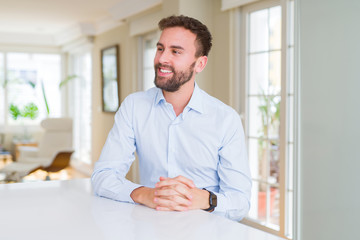 Handsome business man looking away to side with smile on face, natural expression. Laughing confident.