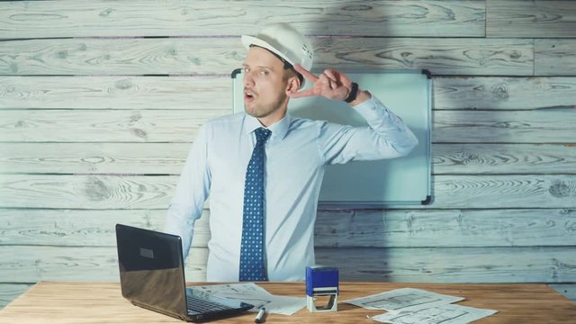 dacing man in a suit with a security helmet. Concept on success in the construction business.