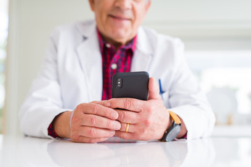 Close up of doctor hands using smartphone at the clinic and smiling