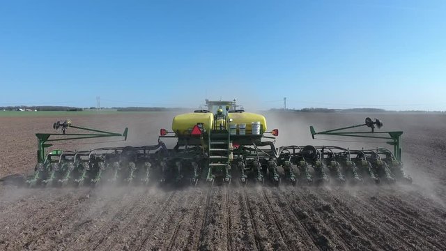 Planting corn, dry beans, sugar beets, soybeans on a farm with a tractor.
