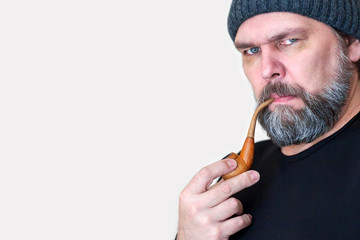 Serious Mature middle-aged man with a beard, Smoking a pipe, looking at the camera.