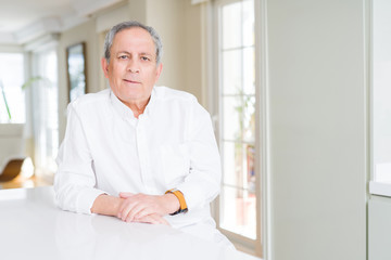 Fototapeta premium Handsome senior man at home with serious expression on face. Simple and natural looking at the camera.