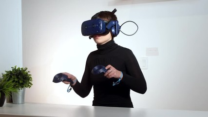 Elegant woman architect imagining architectural project with virtual reality glasses sitting at working place. young girl interior designer wearing vr goggles creative idea at desk. - Powered by Adobe