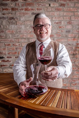 Man tasting Wine in front of a red brick stonewall