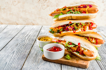 Homemade hot dogs with fresh greens, sausages and sauces, white wooden background copy space top view