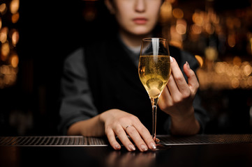 Close shot of glass full of sparkling wine in bartender's hands