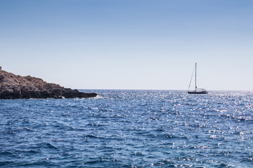 Obraz premium Island stone shore and sailing boat